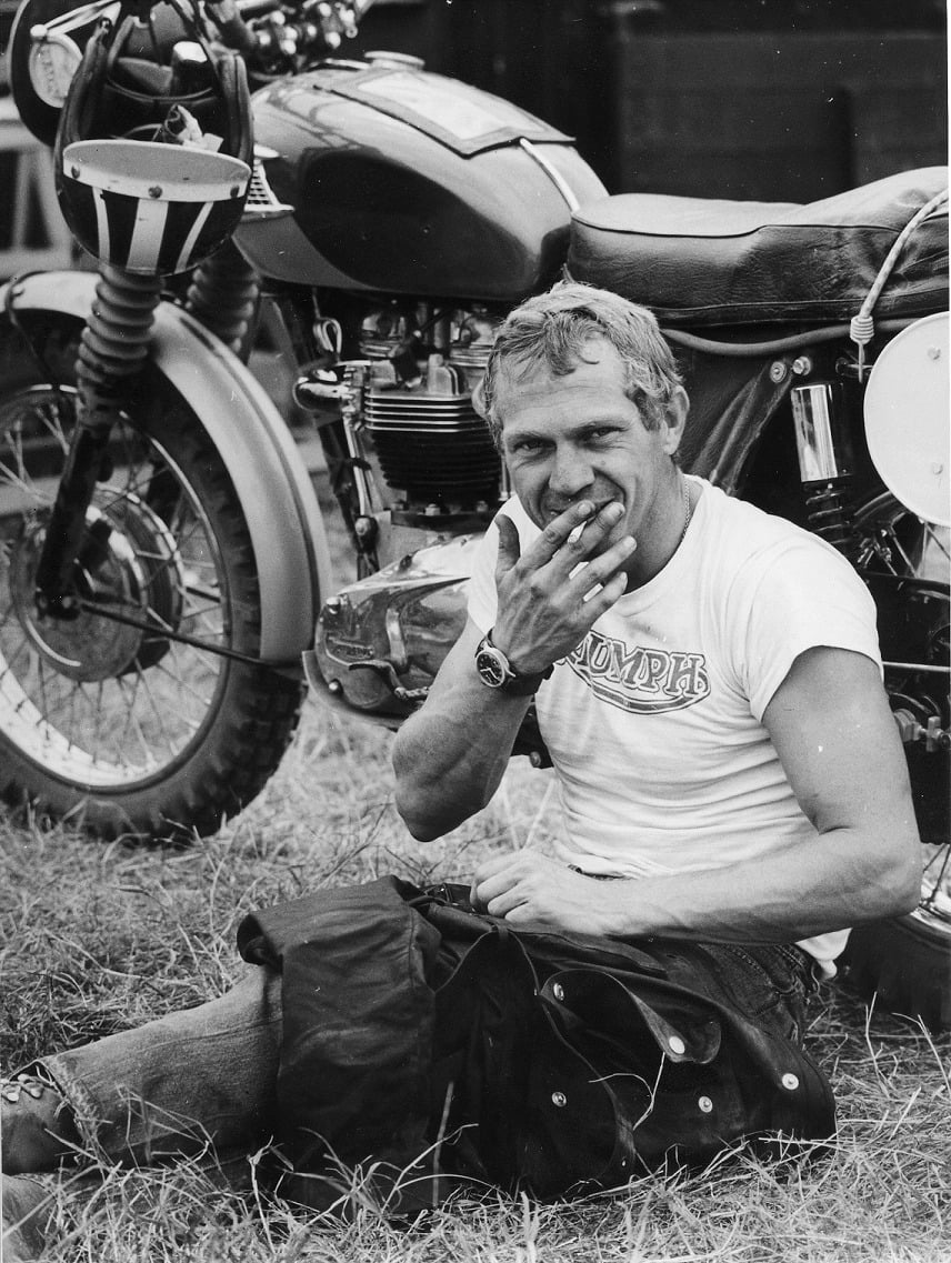 Steve McQueen smiling with his motorcycle